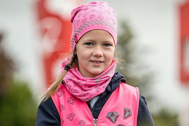 Mädchen mit rosafarbenen Jersey-Halstuch und Mütze 